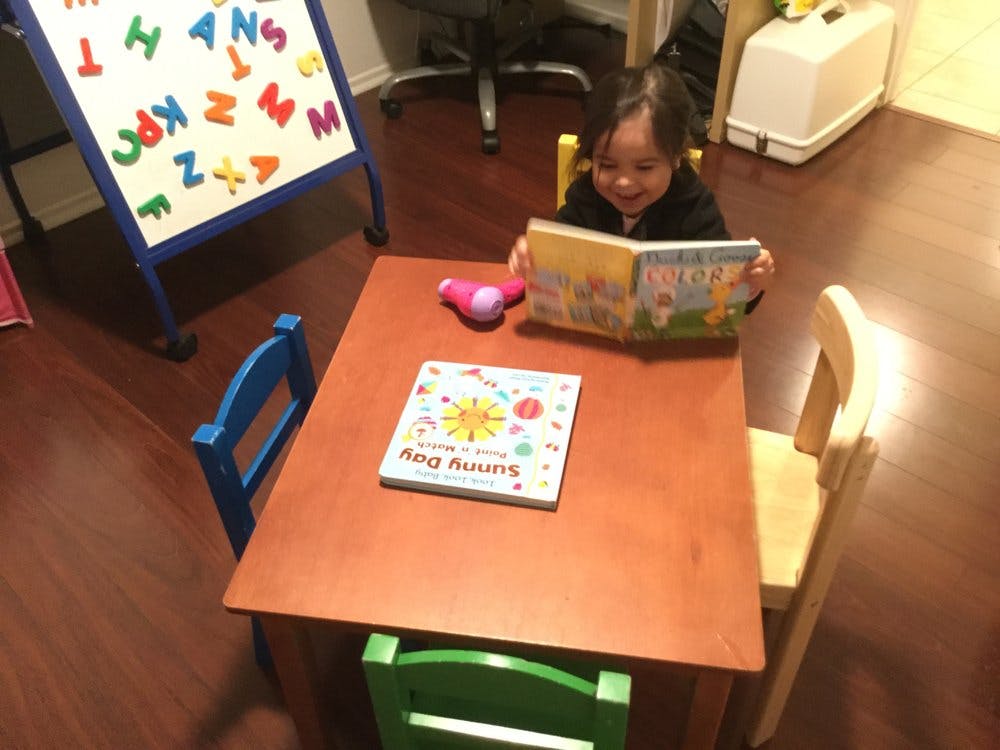 Child sitting at a table reading a book