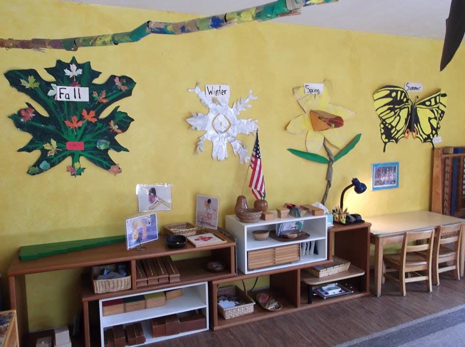 Classroom wall with seasonal decorations and shelves with learning materials