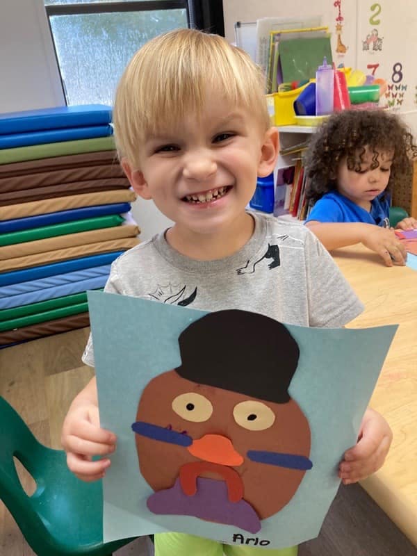 Child holding up a paper craft of a turkey