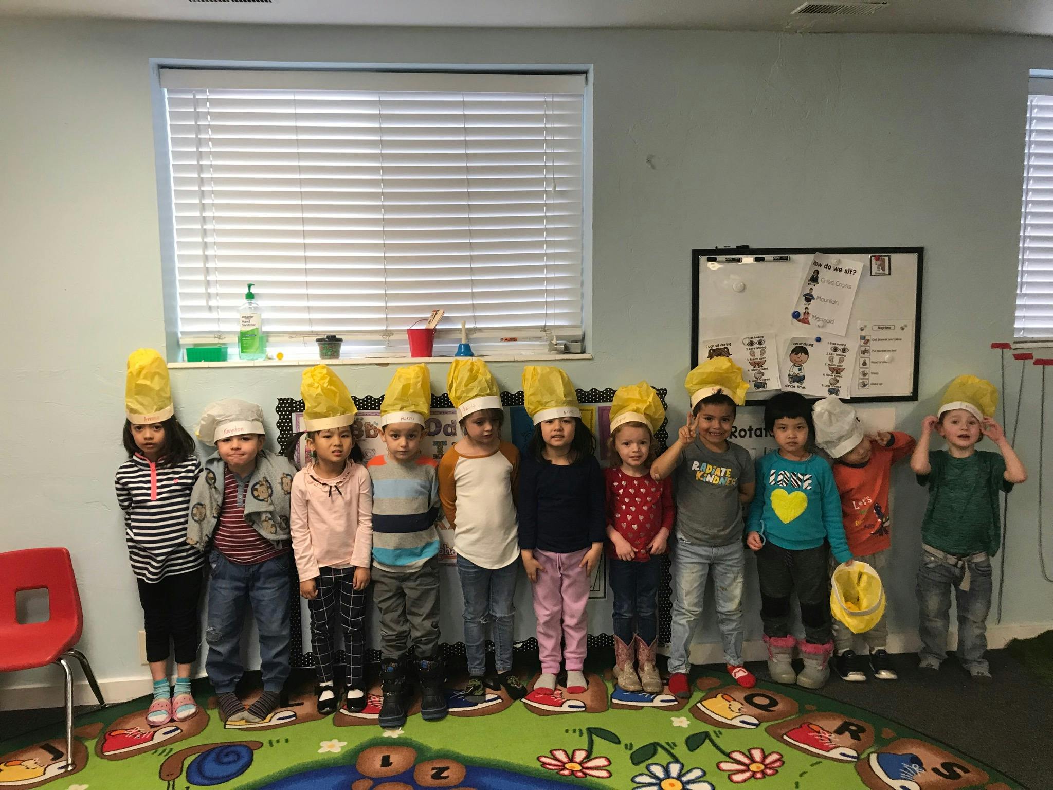 Children wearing yellow chef hats standing in a line