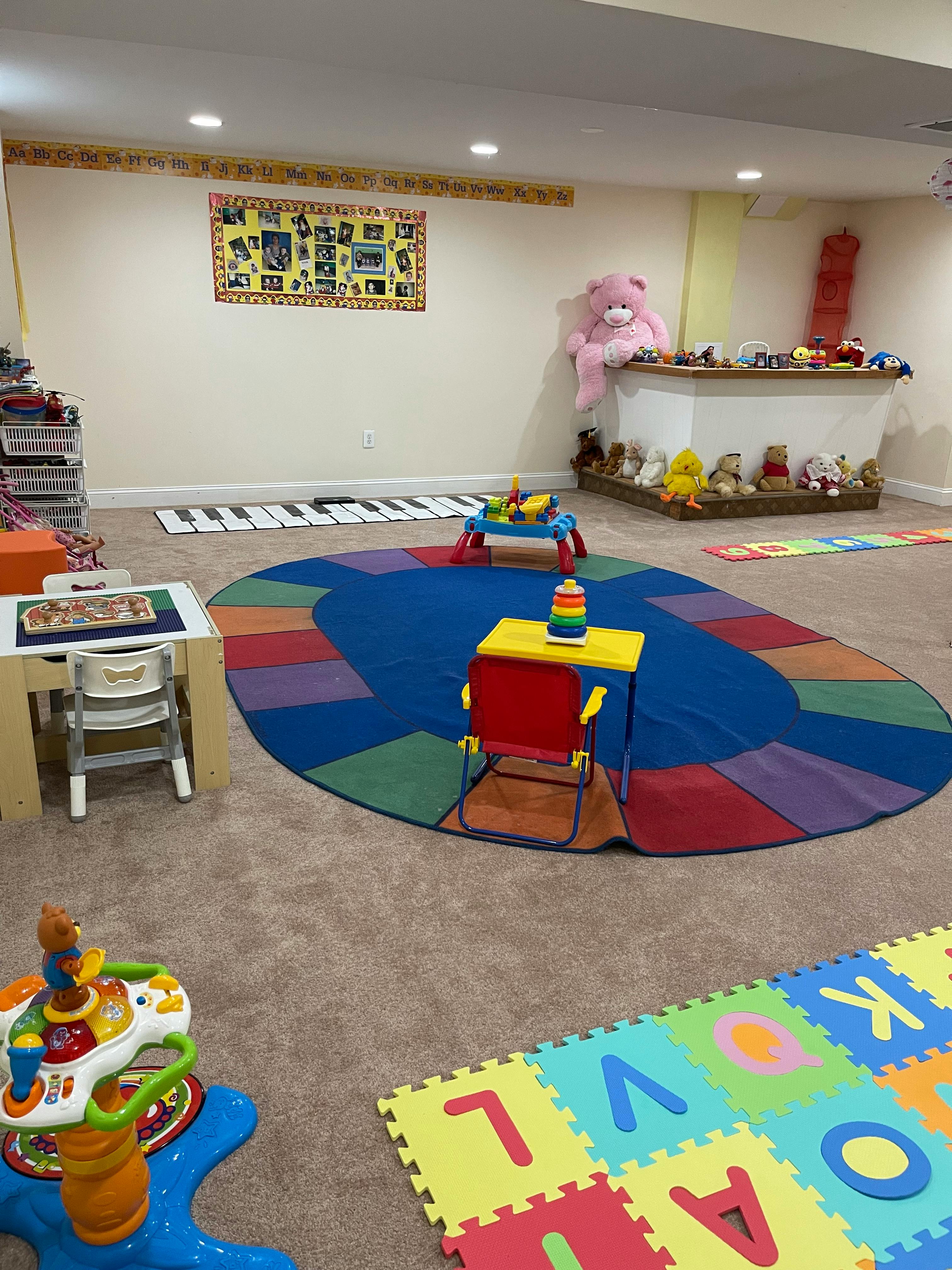 Playroom with colorful rugs, small tables, and toys