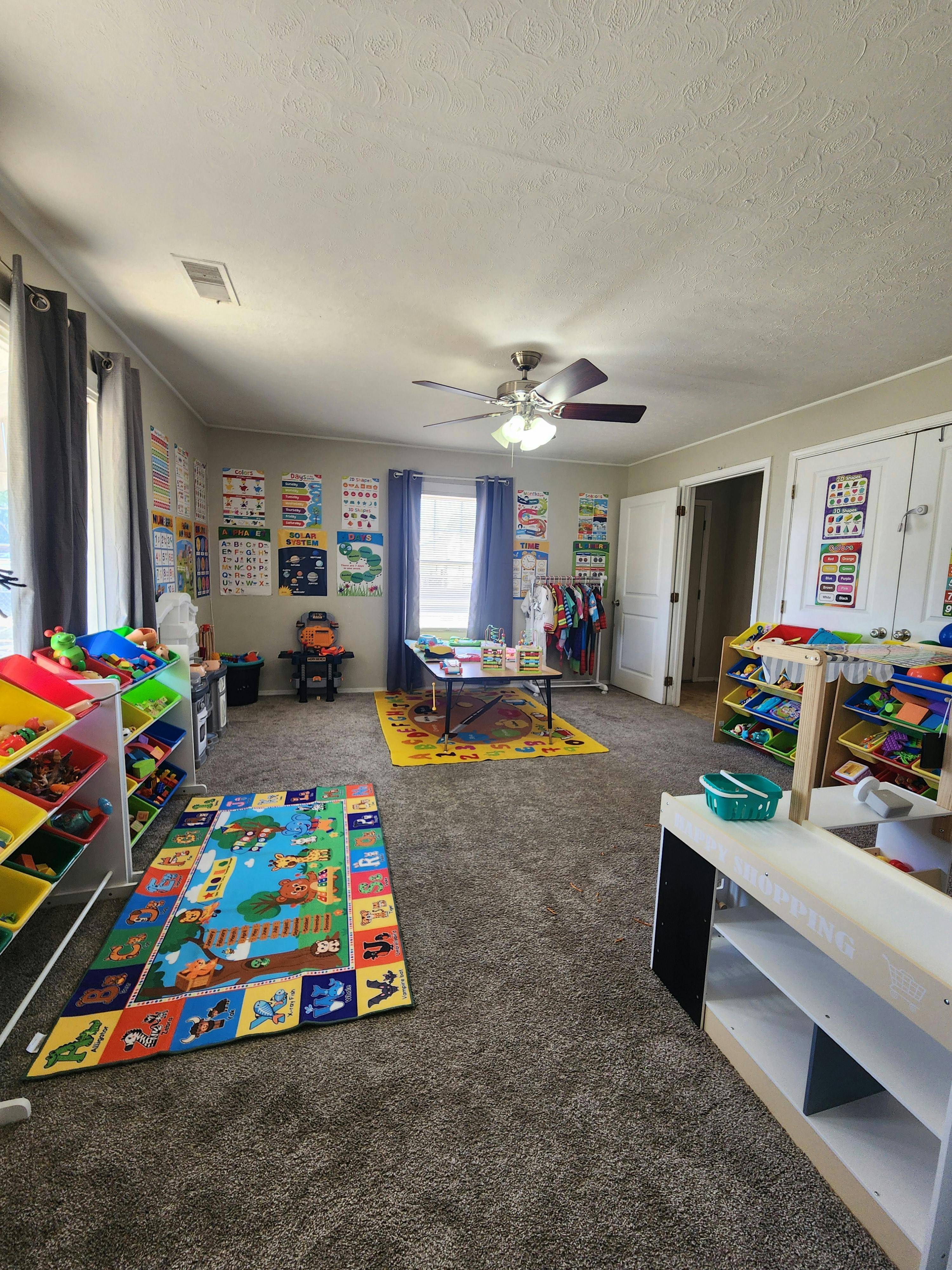 Playroom with educational rugs and shelves filled with toys