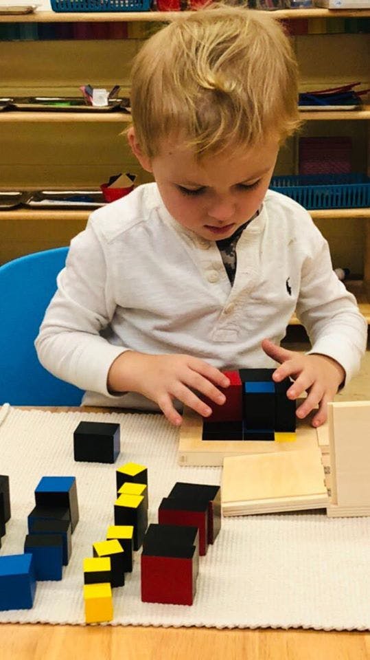 Child playing with colorful blocks on a table