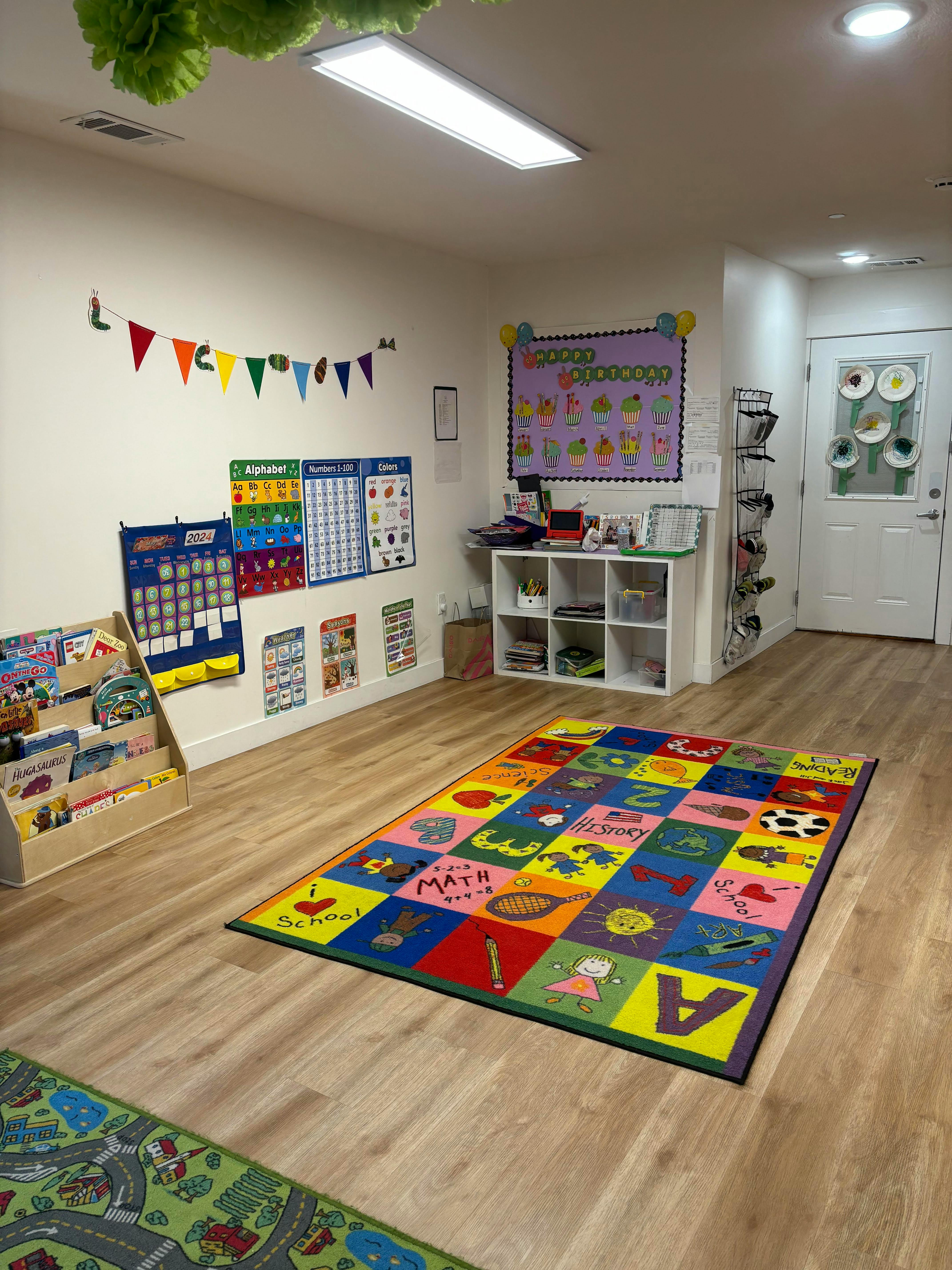 Classroom with colorful rug, wall decorations, and book display