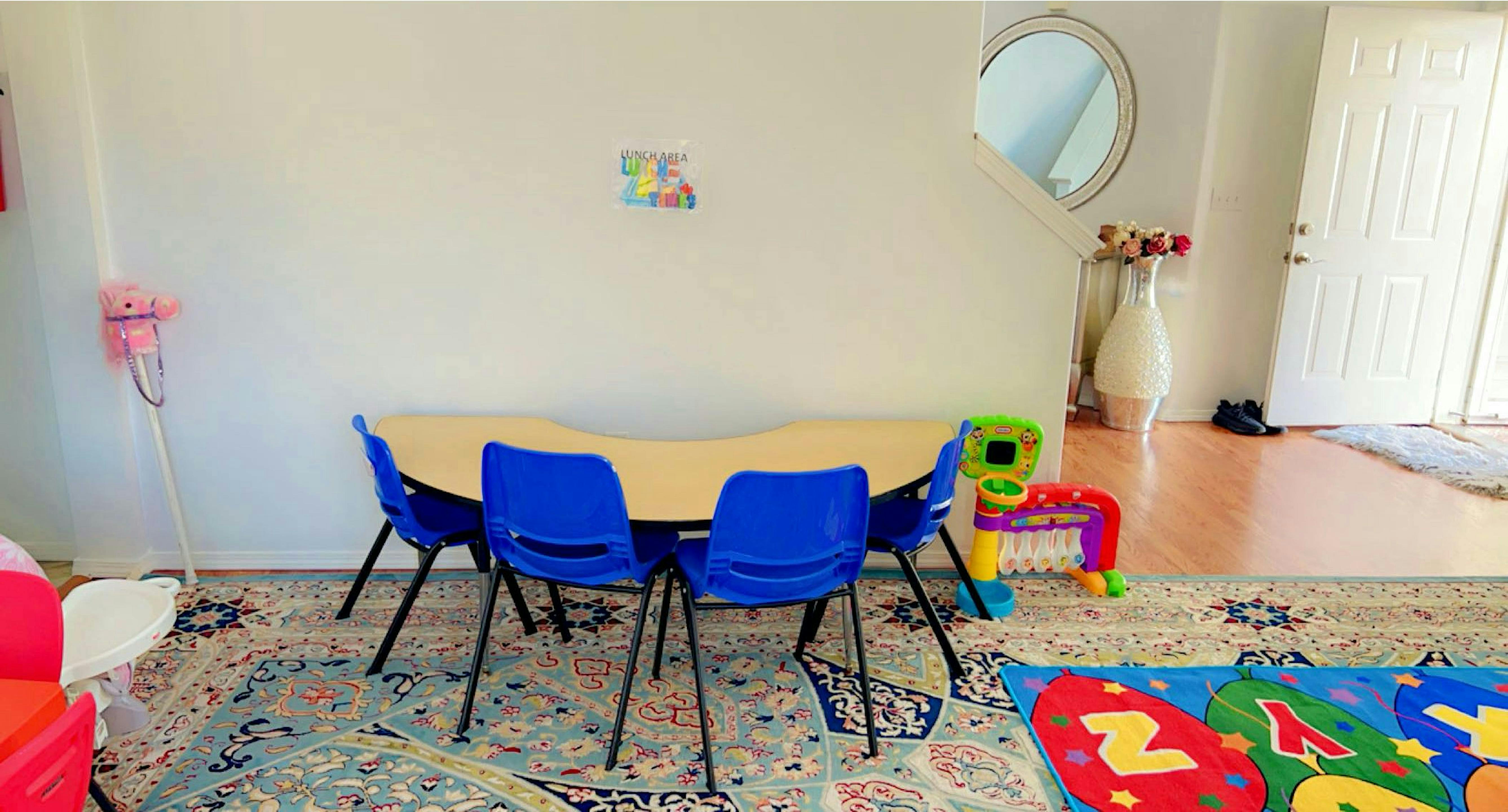 Small table with blue chairs in a room with a colorful rug