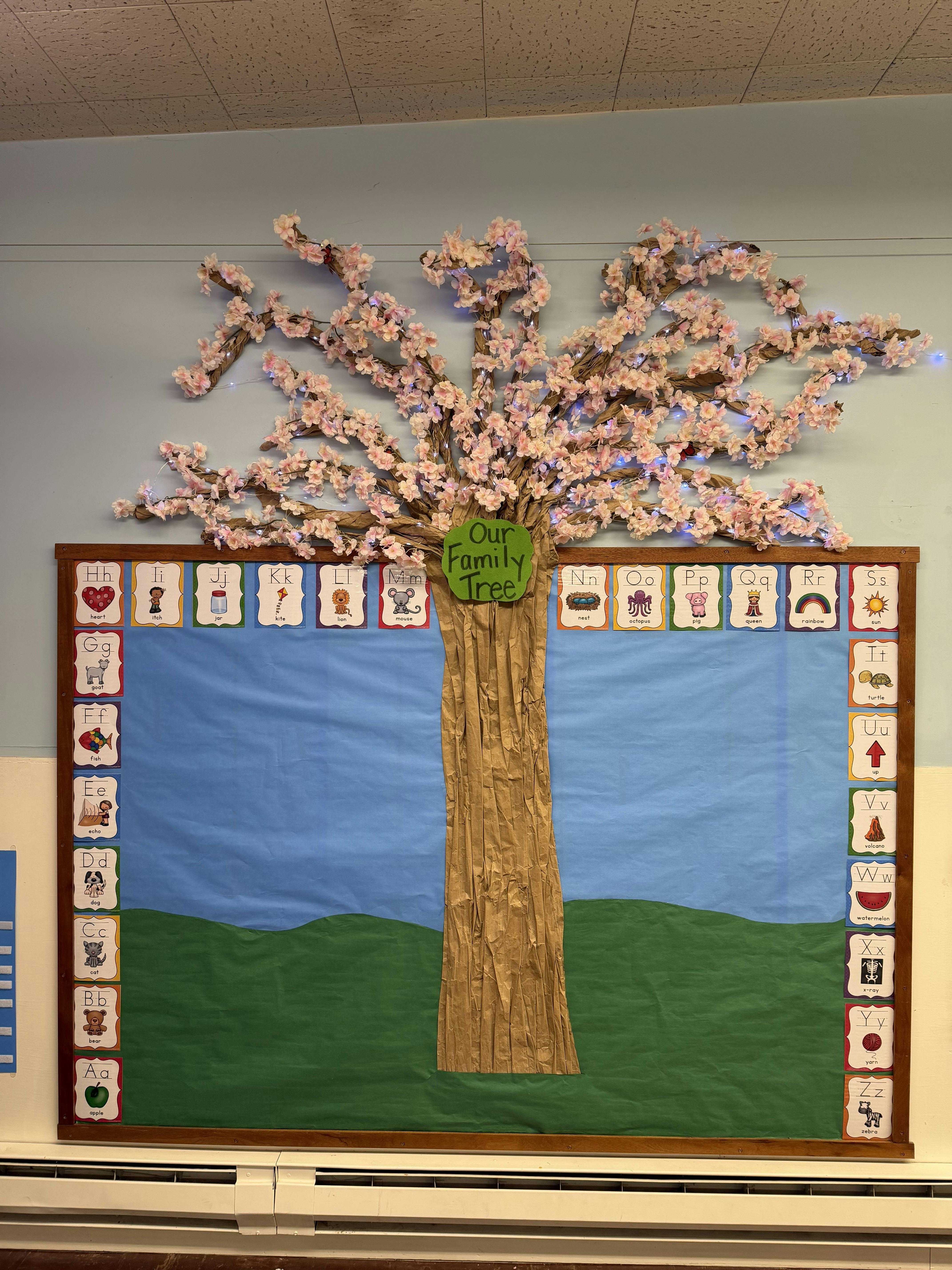 Classroom bulletin board with an artificial tree and alphabet cards