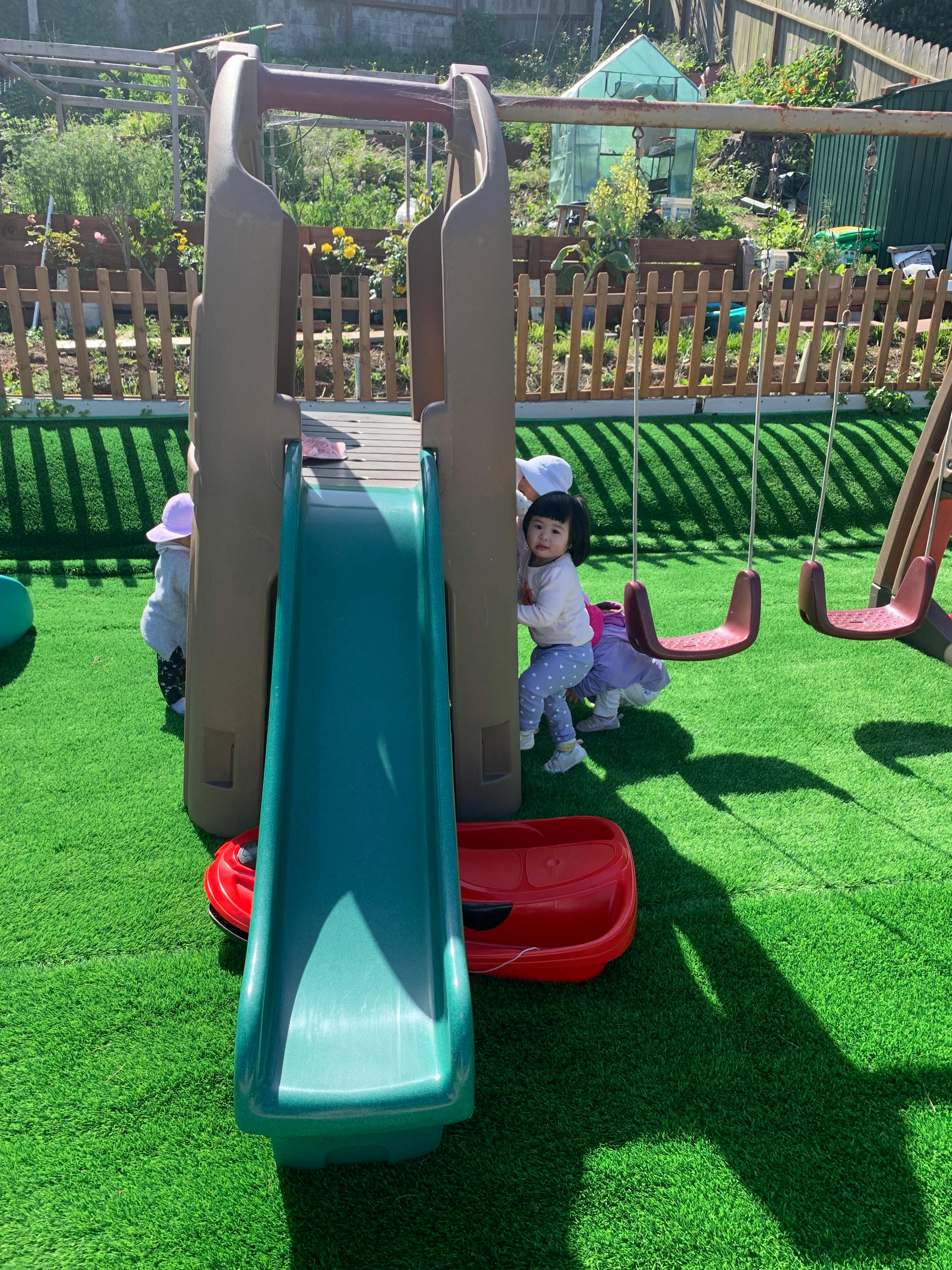 Child playing on a slide in a backyard
