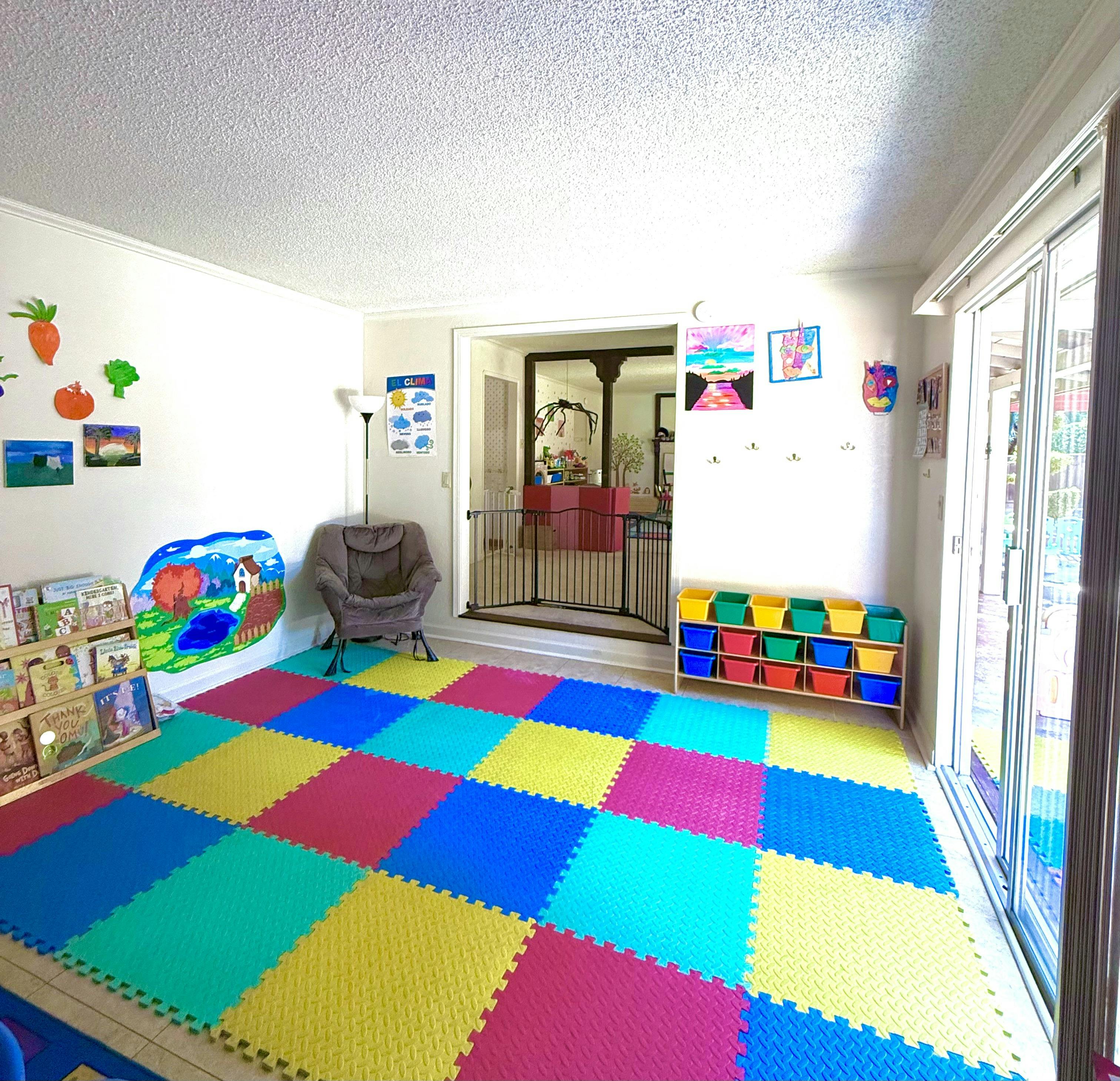Playroom with colorful floor mats and children's book display