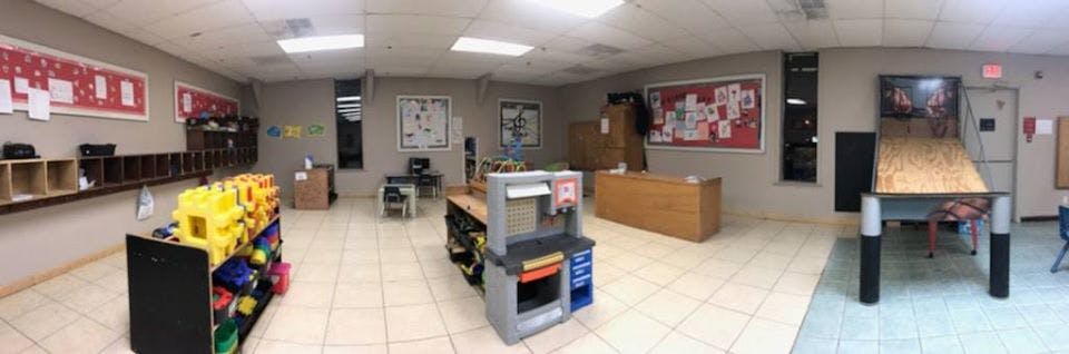 Room with cubbies, play kitchen, and tables