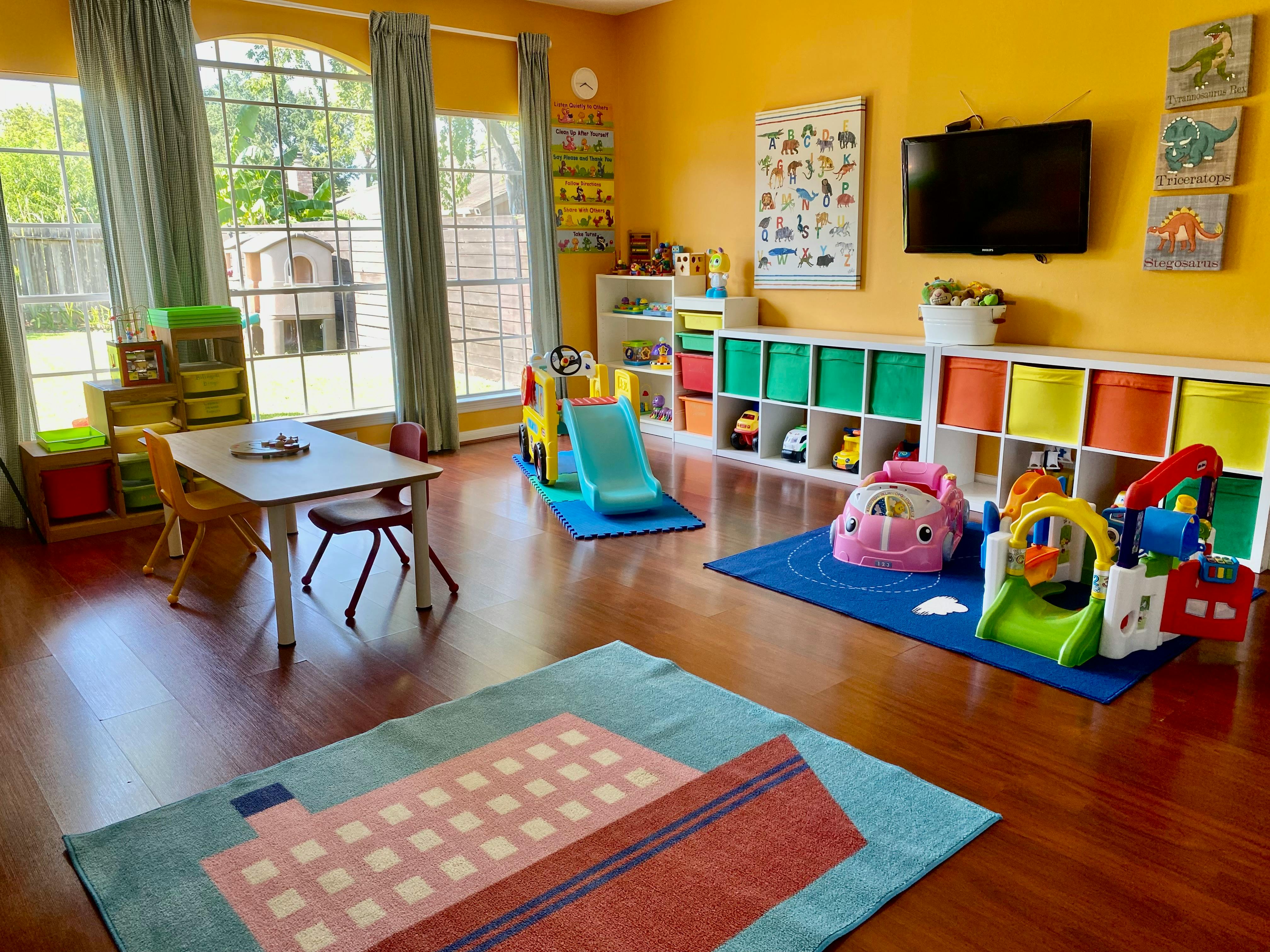 Playroom with small table and chairs, toy storage, and play equipment