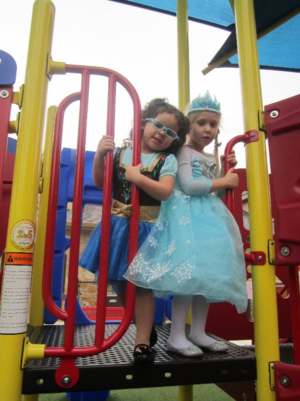 Two children in costumes on a playground structure