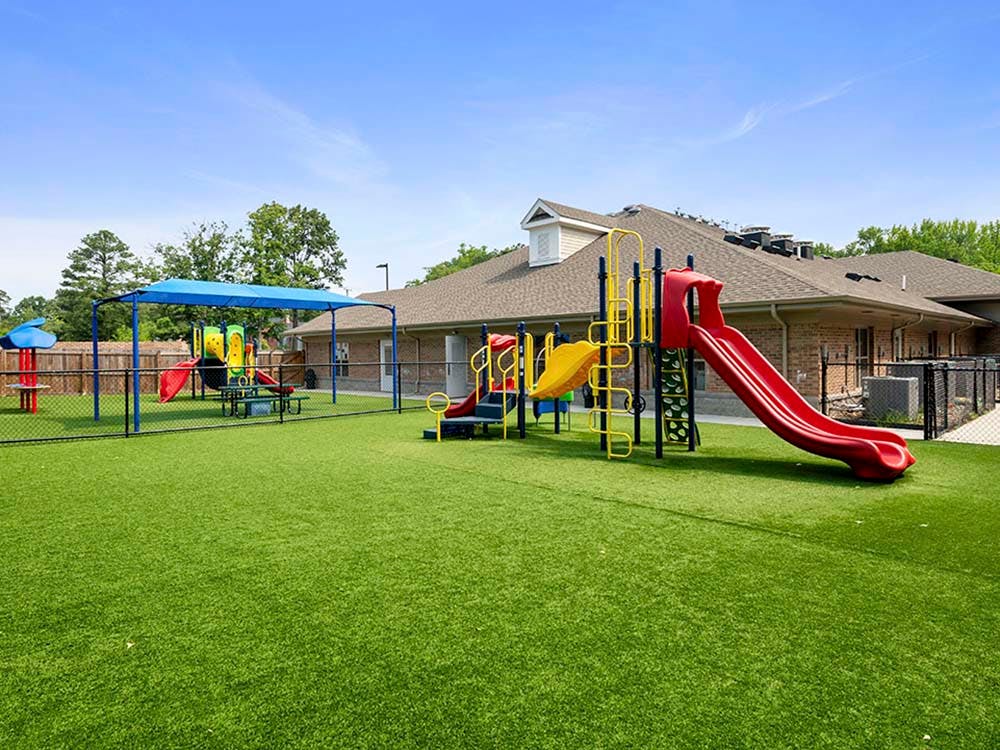 Playground with various slides and climbing structures on artificial turf