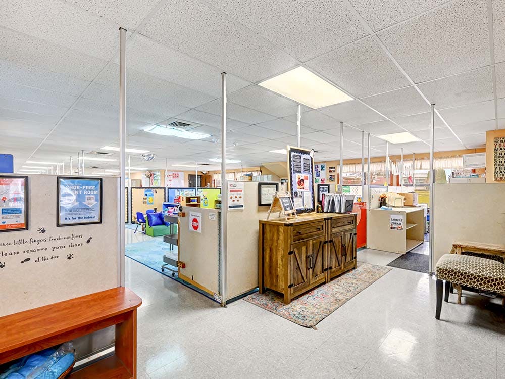 An empty childcare or preschool room with cubbies and tables