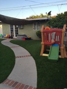 backyard with a winding path and a child's slide set with a slide