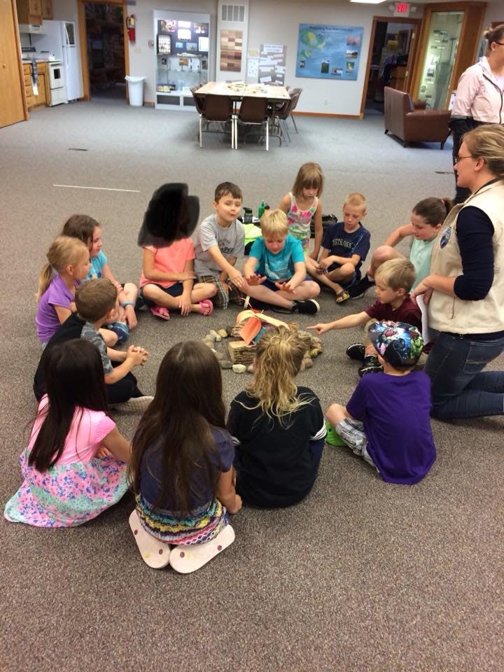 Adult and children sitting in a circle on the floor