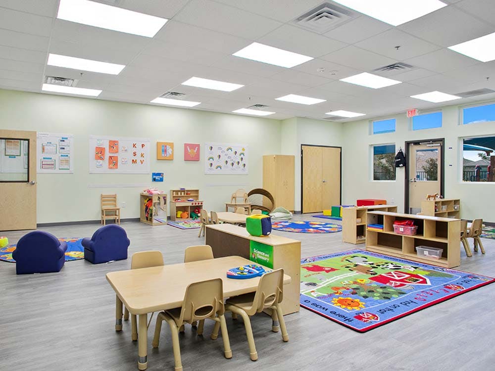 Empty colorful children's classroom with small chairs and tables