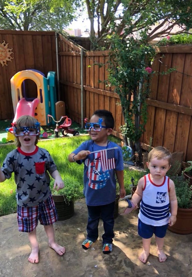 Three children in patriotic attire and glasses in a backyard
