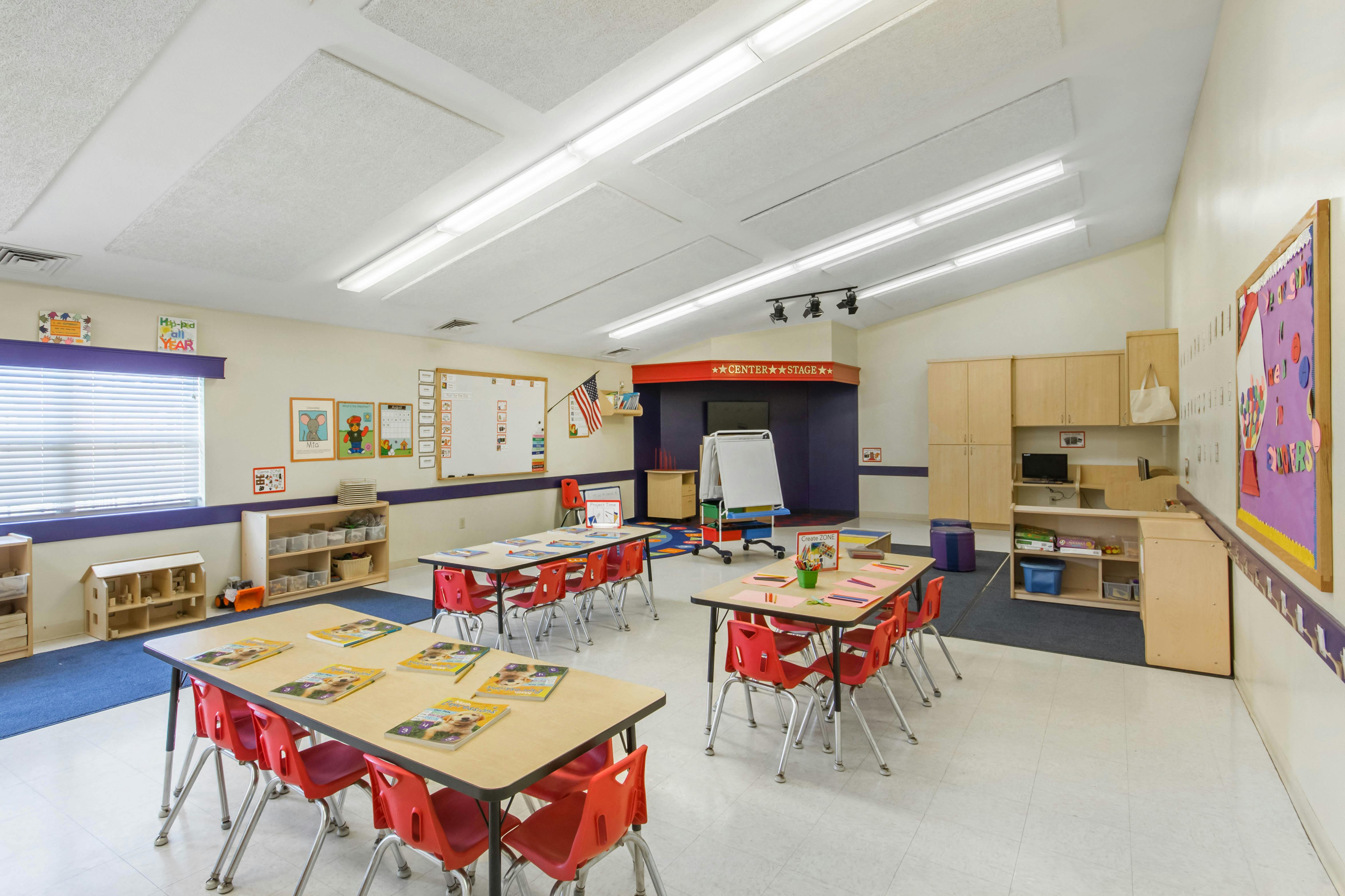 Classroom with child-sized tables and chairs, toys, and classroom decorations