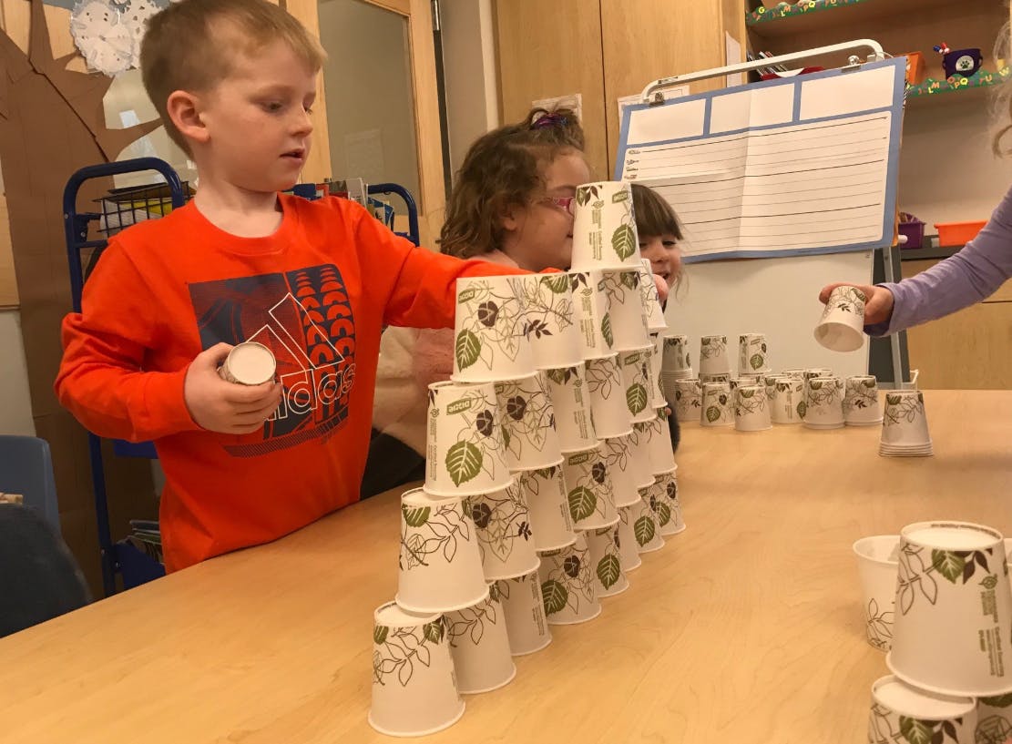 Child building a tower with paper cups