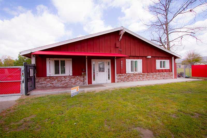 Red building with white trim and a red awning