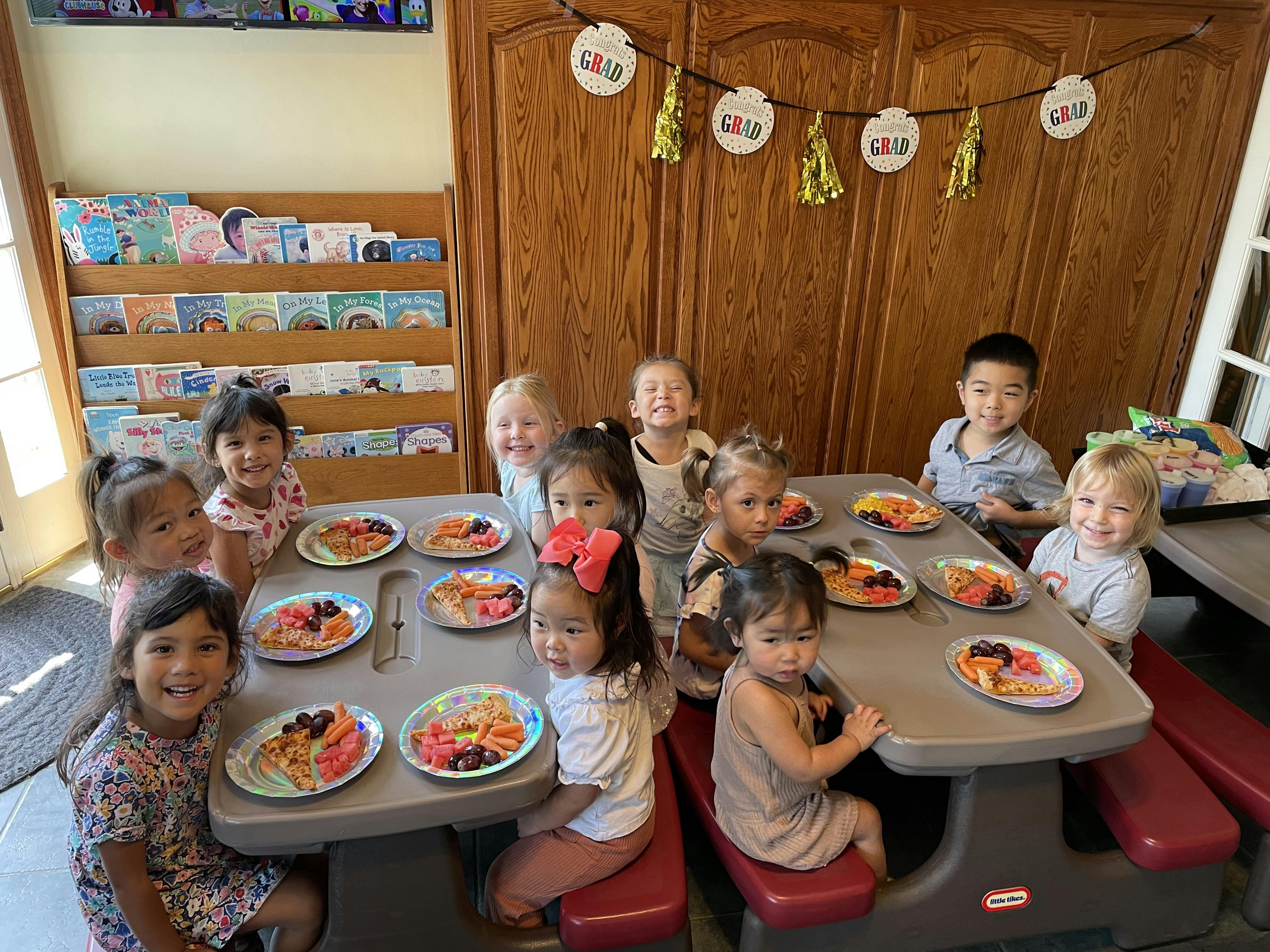 Children sitting at a table with plates of food