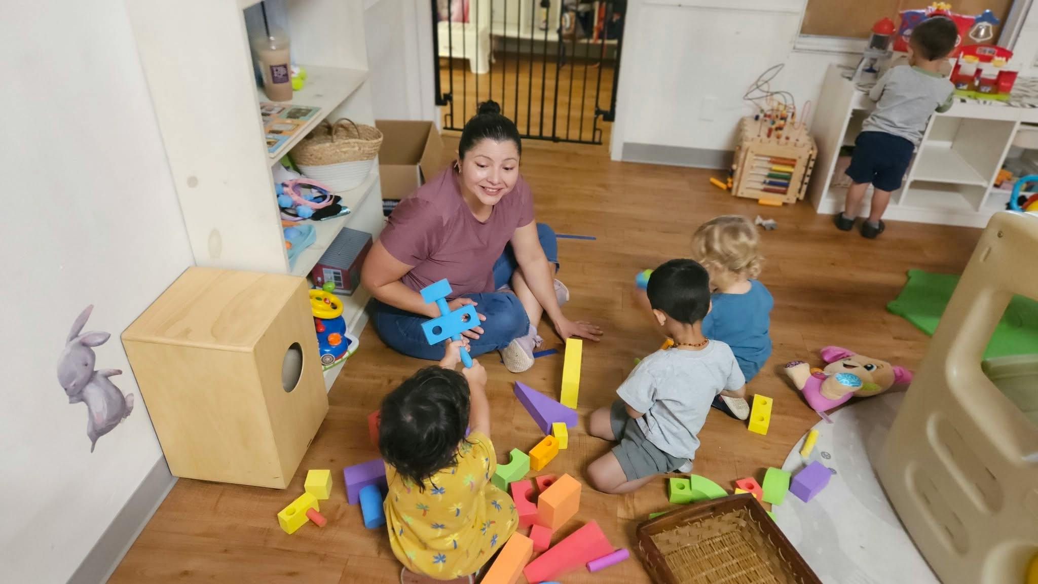 Adult and children playing with building blocks in a playroom