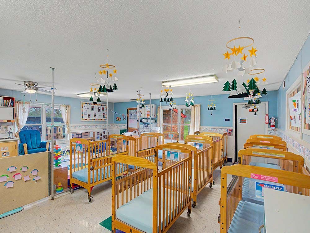 cribs with mattresses in a nursery room