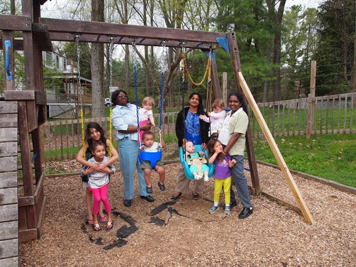 Adults and children on a playground swing set
