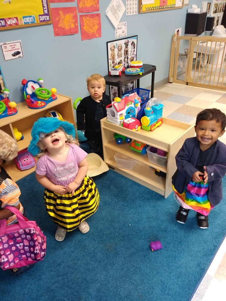Three children playing with toys in a classroom