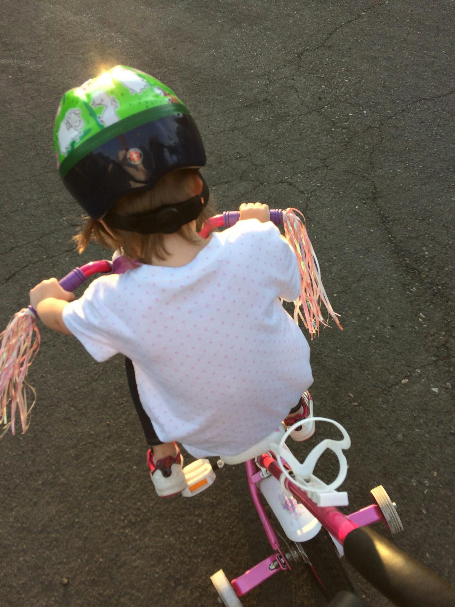 Child wearing a helmet riding a tricycle