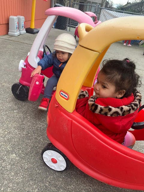 Two children in toy cars