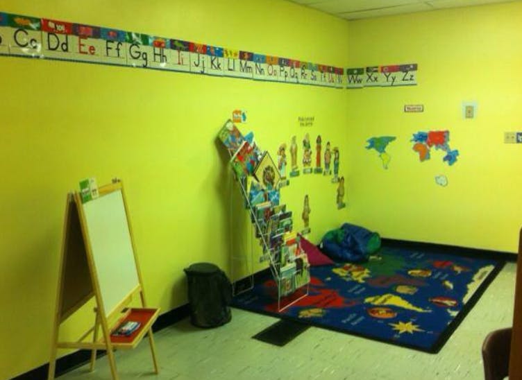 Classroom with an alphabet border, world map rug, and book display