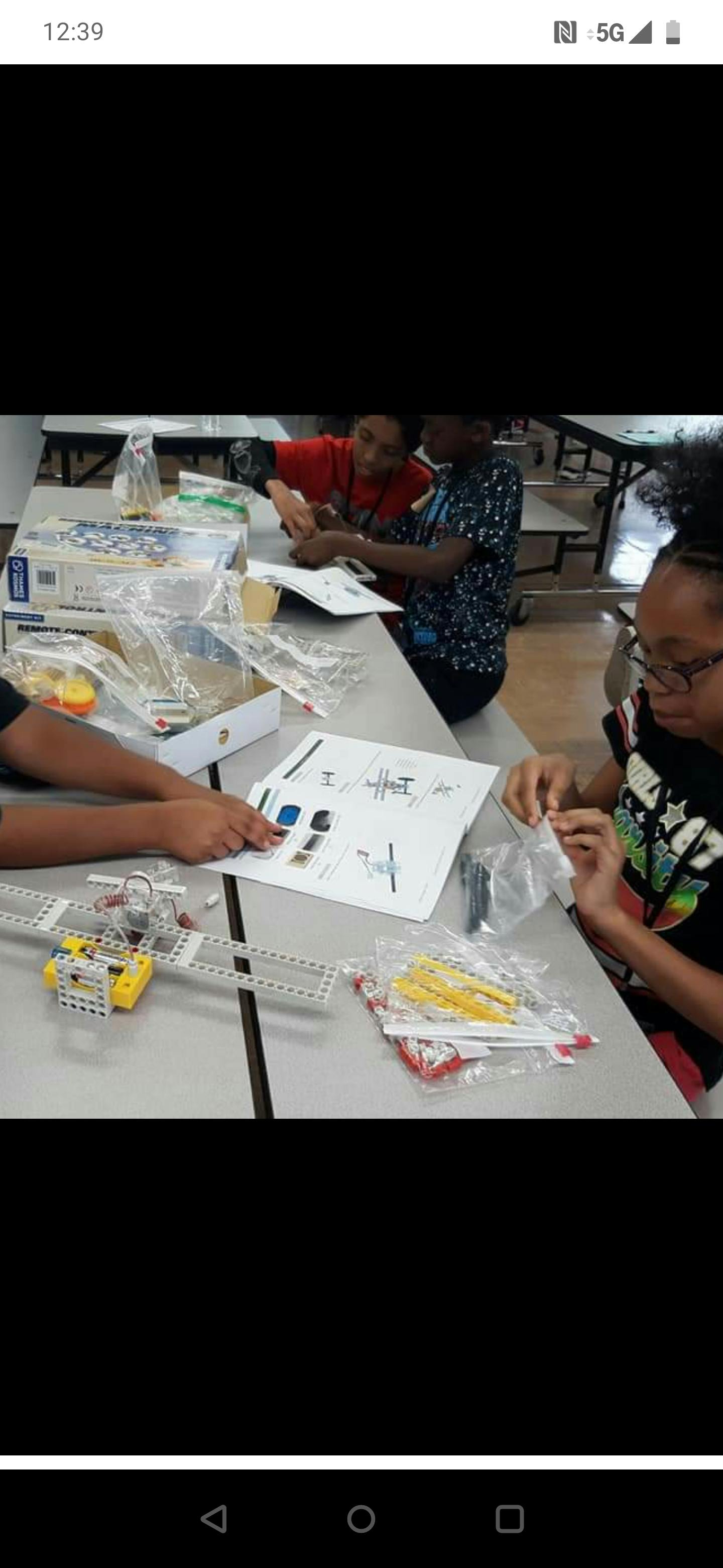 Children assembling a model from a kit at a table