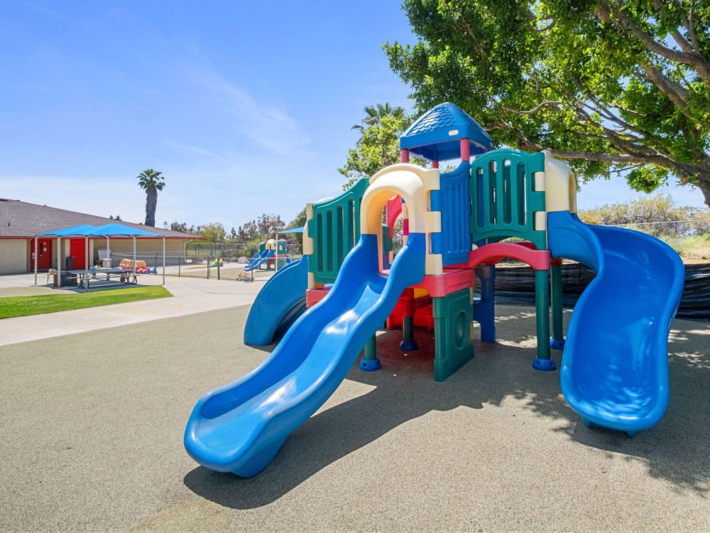 A colorful playground with multiple slides and climbing structures