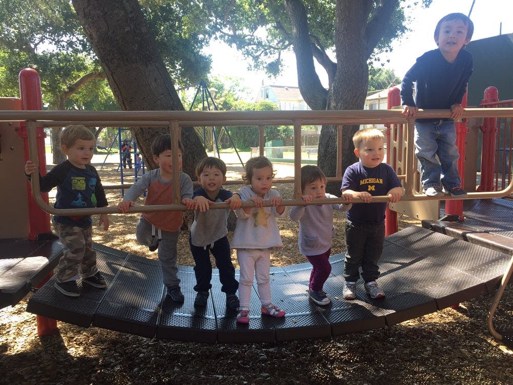 Group of children standing on a playground structure