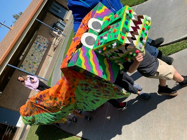 Children holding a colorful dragon puppet