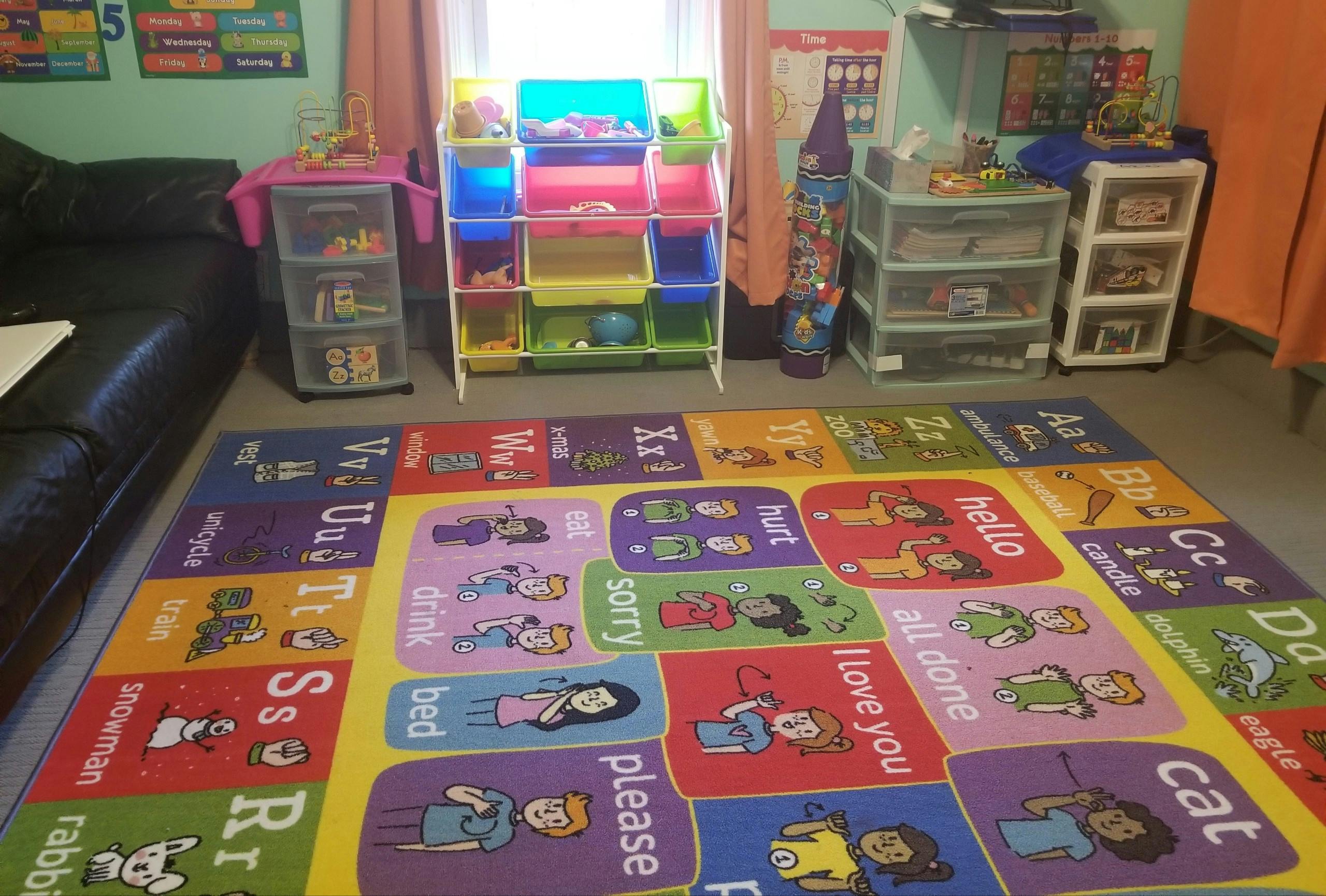 Colorful alphabet rug in a room with toy storage shelves