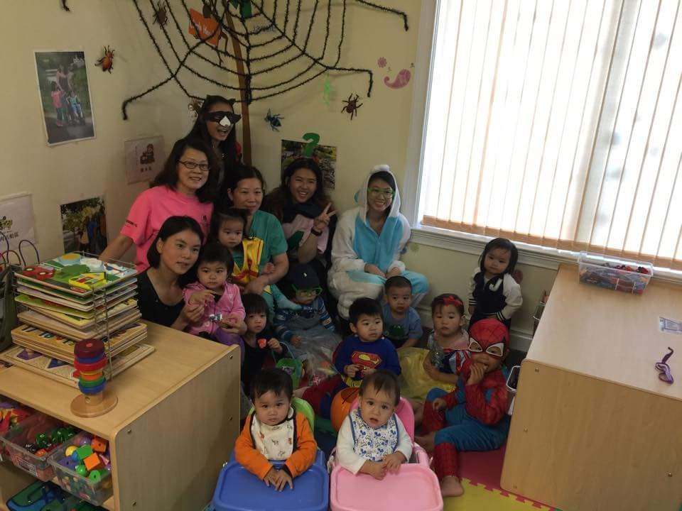 Group of adults and children in a room with Halloween decorations