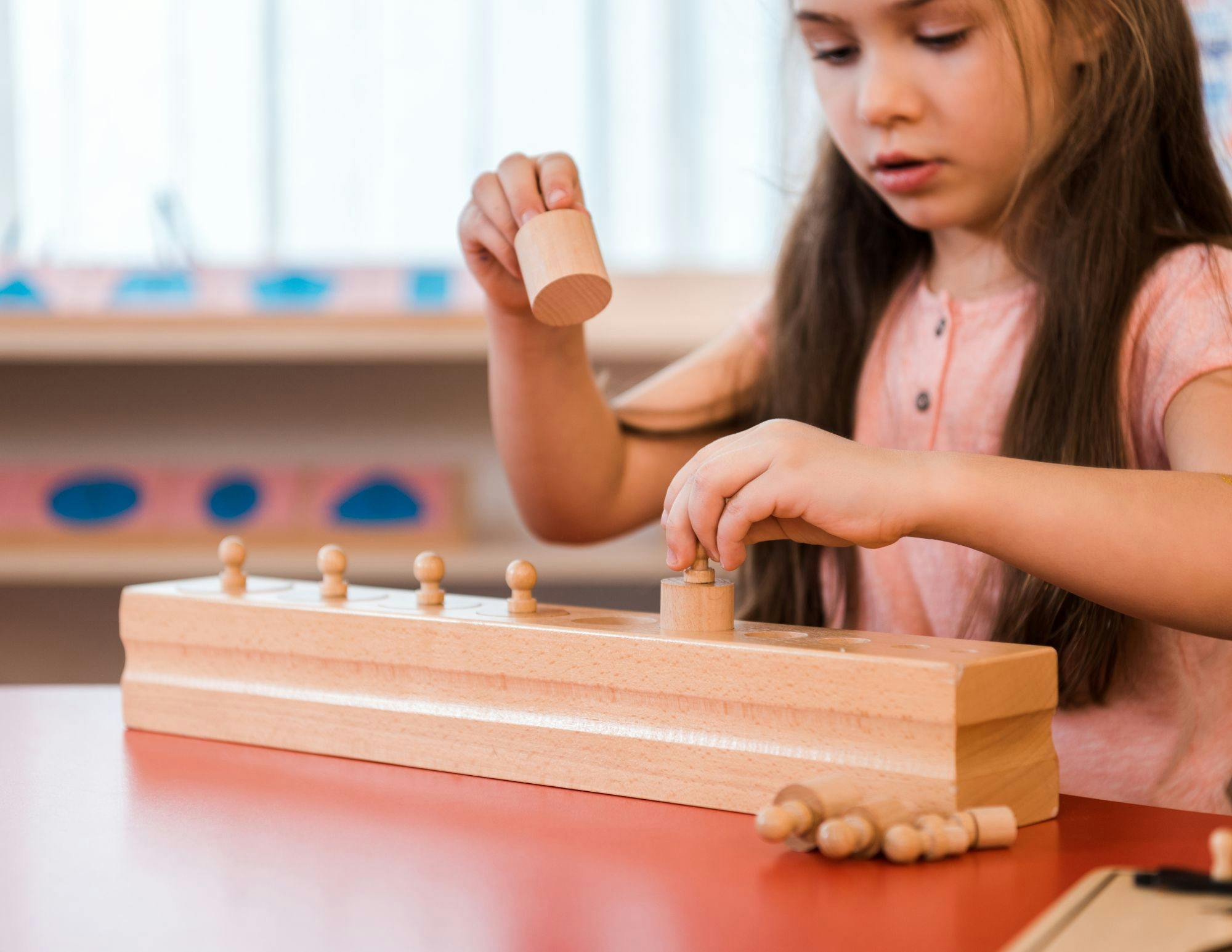Child playing with wooden cylinder blocks