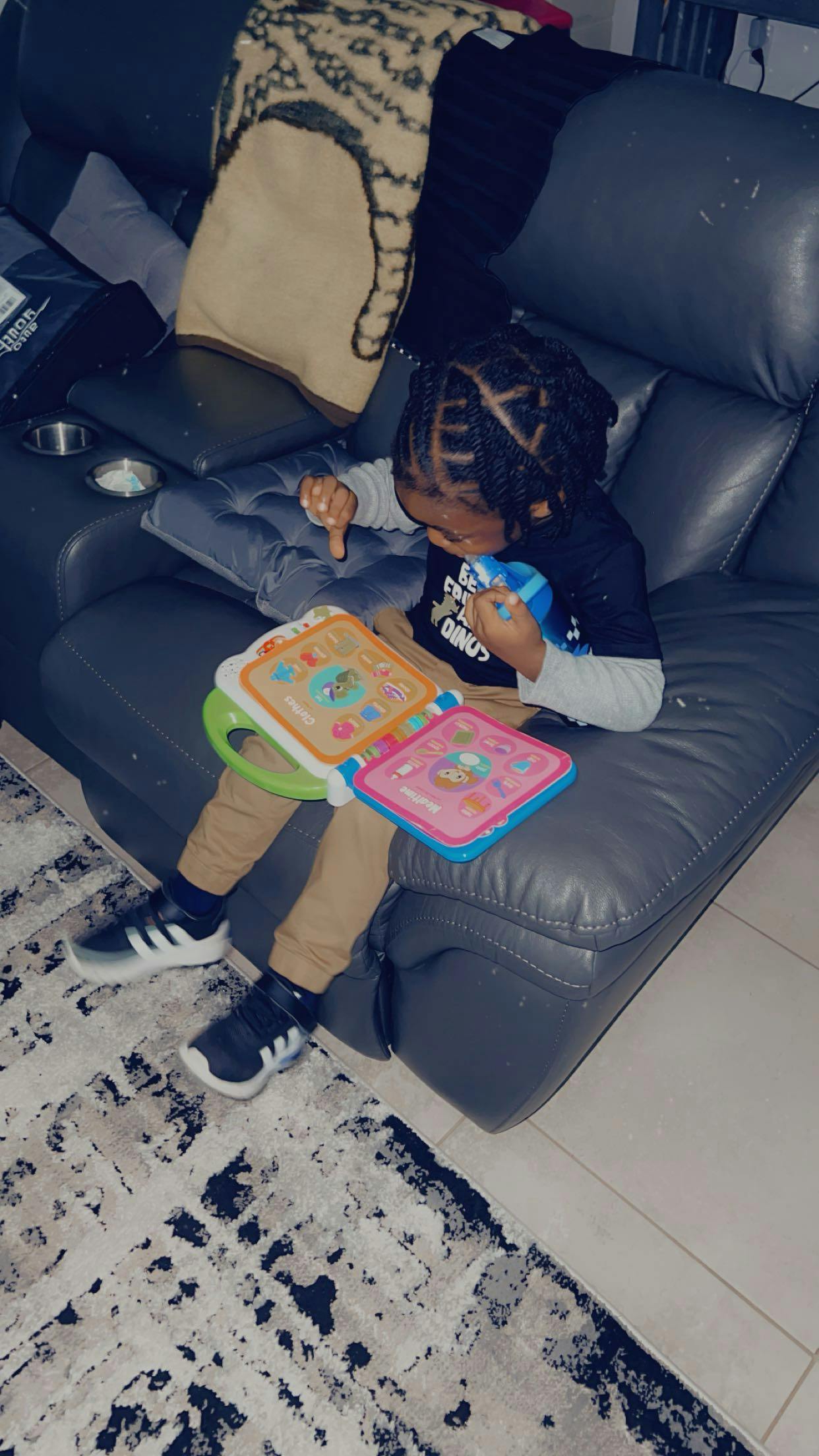 Child sitting on a couch playing with a colorful toy