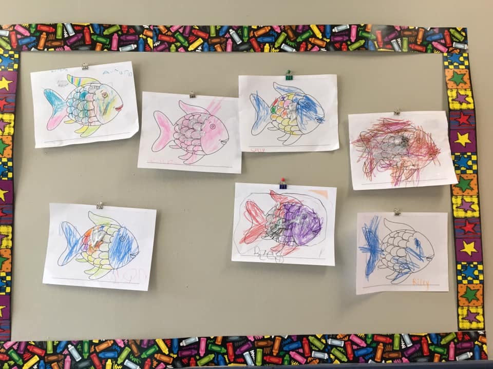 Children's drawings of fish displayed on a bulletin board