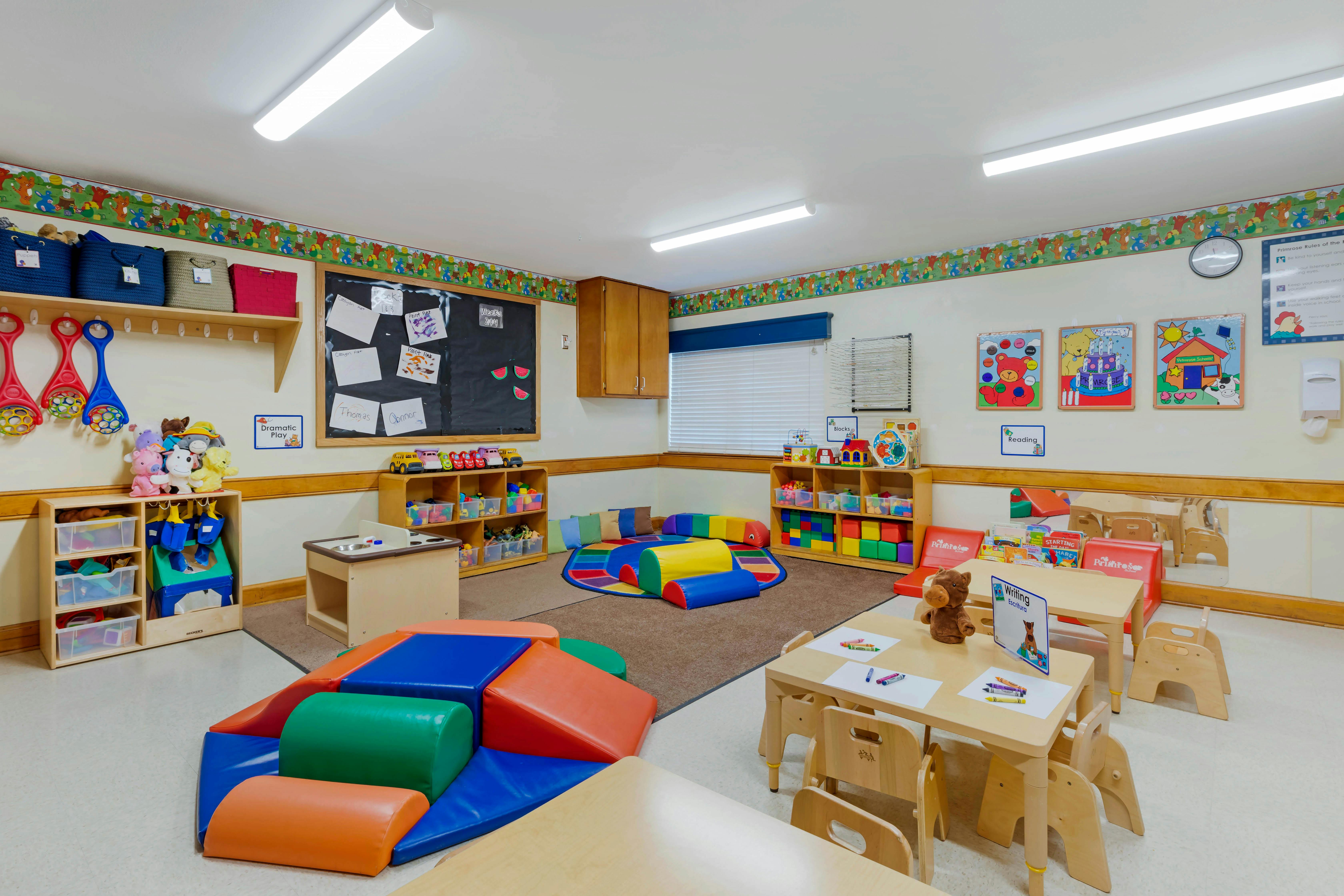 Colorful playroom with small tables, chairs, and soft play equipment