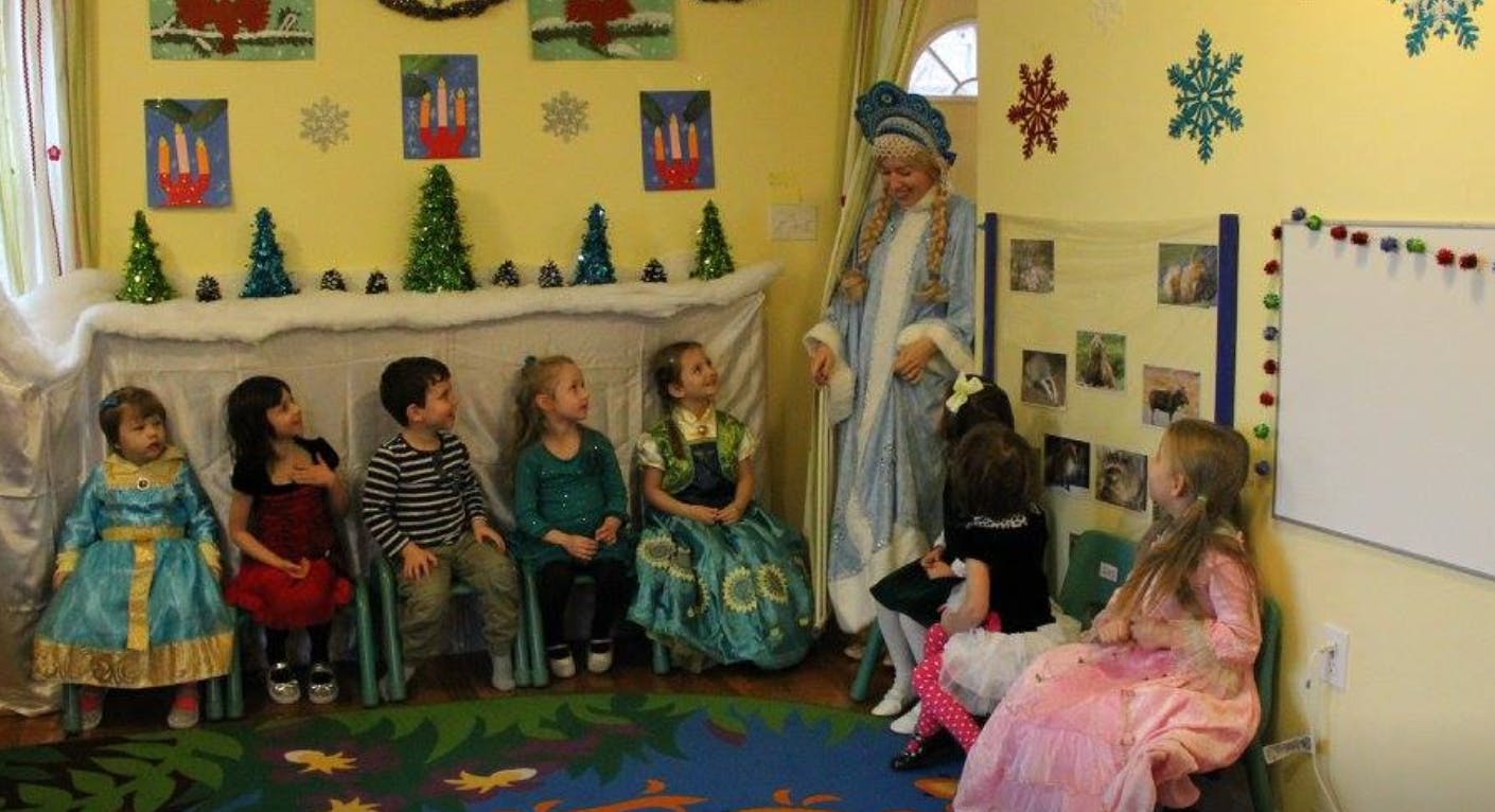 Adult in costume with children in a decorated room