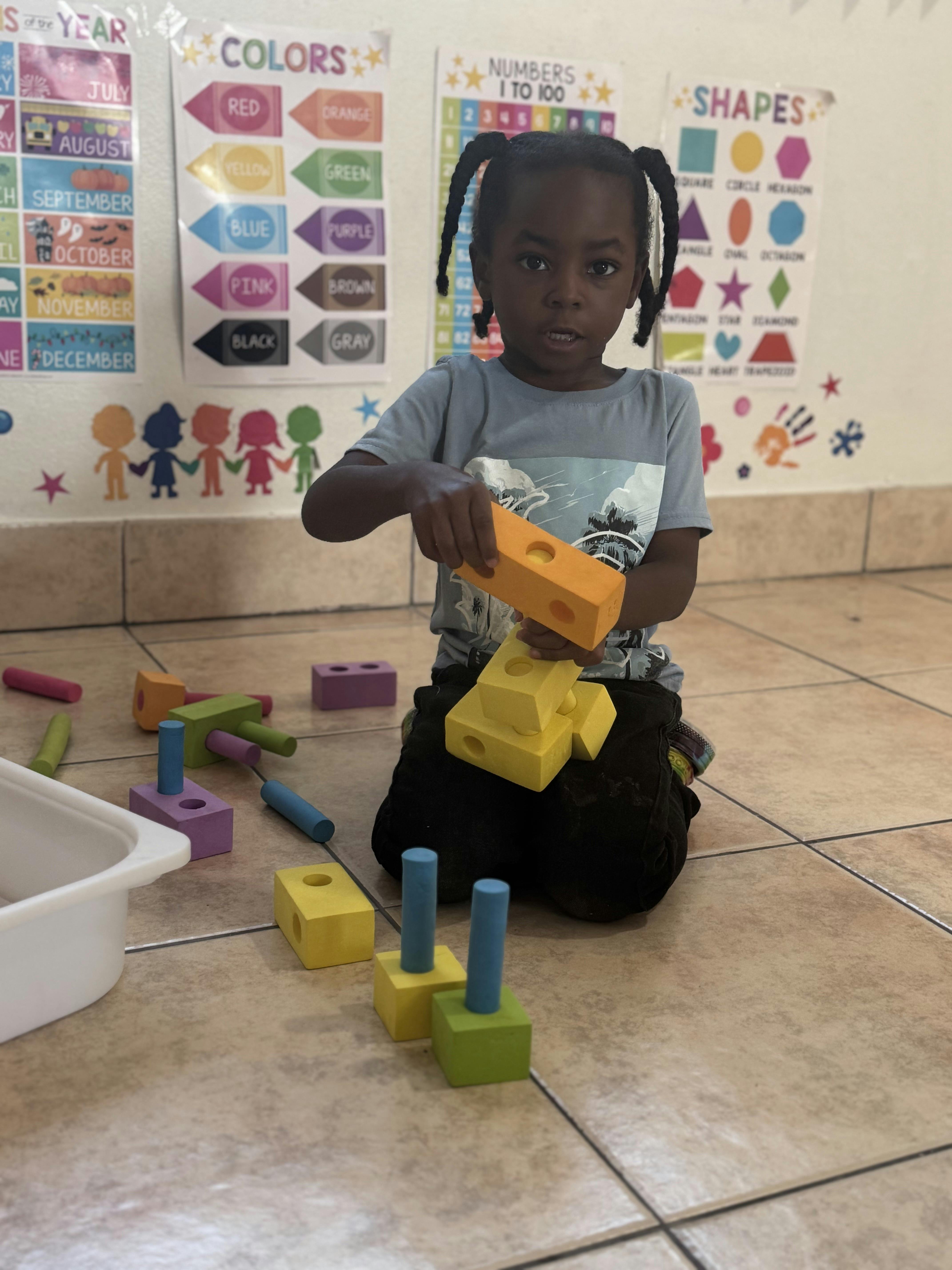 Child building with colorful blocks on a classroom floor