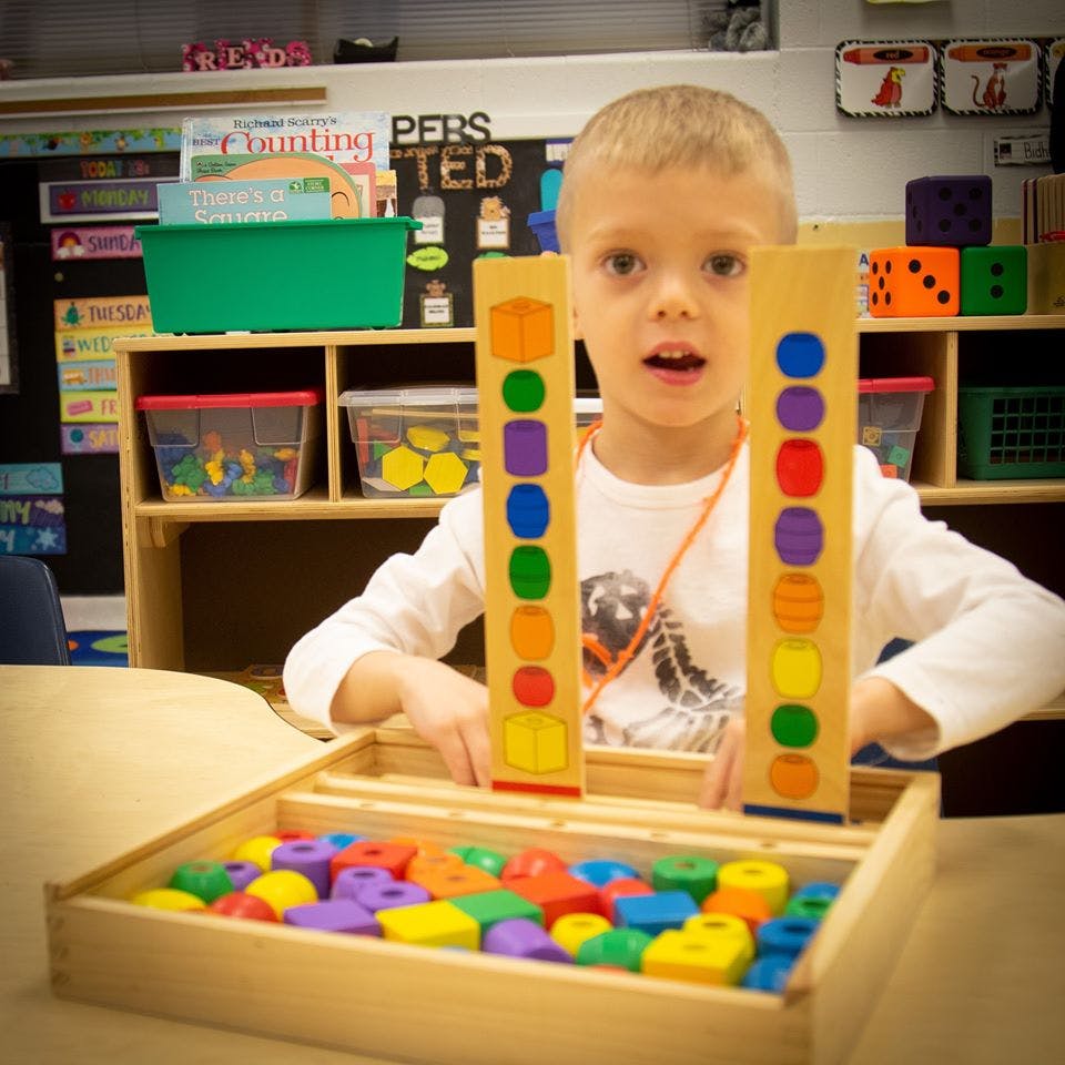 Child playing with colorful shape sorter toy