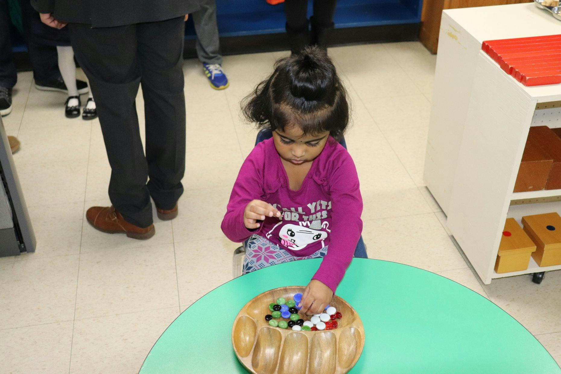 Child playing with marbles at a table