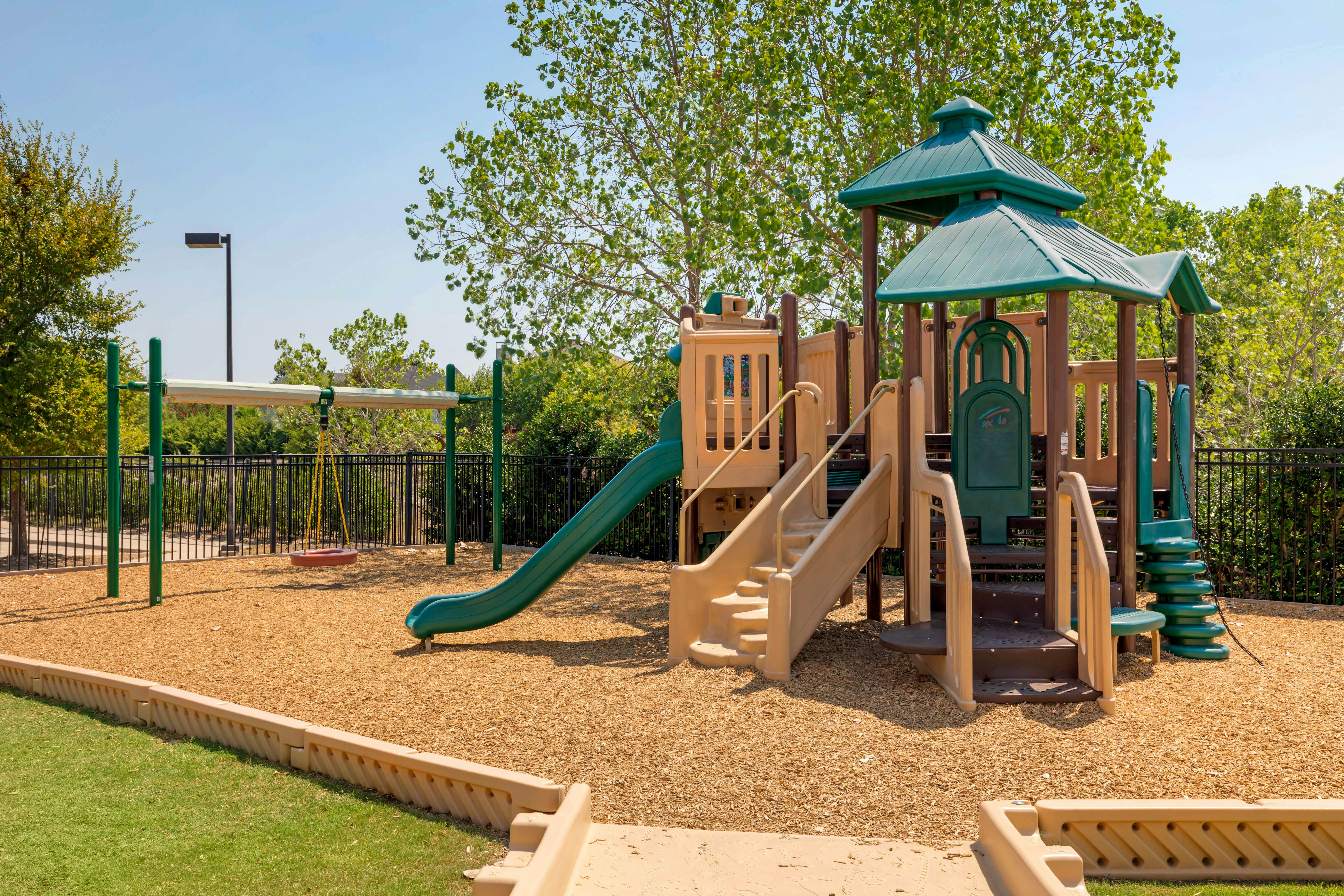 Empty outdoor playground with slides, swings, and a climbing structure