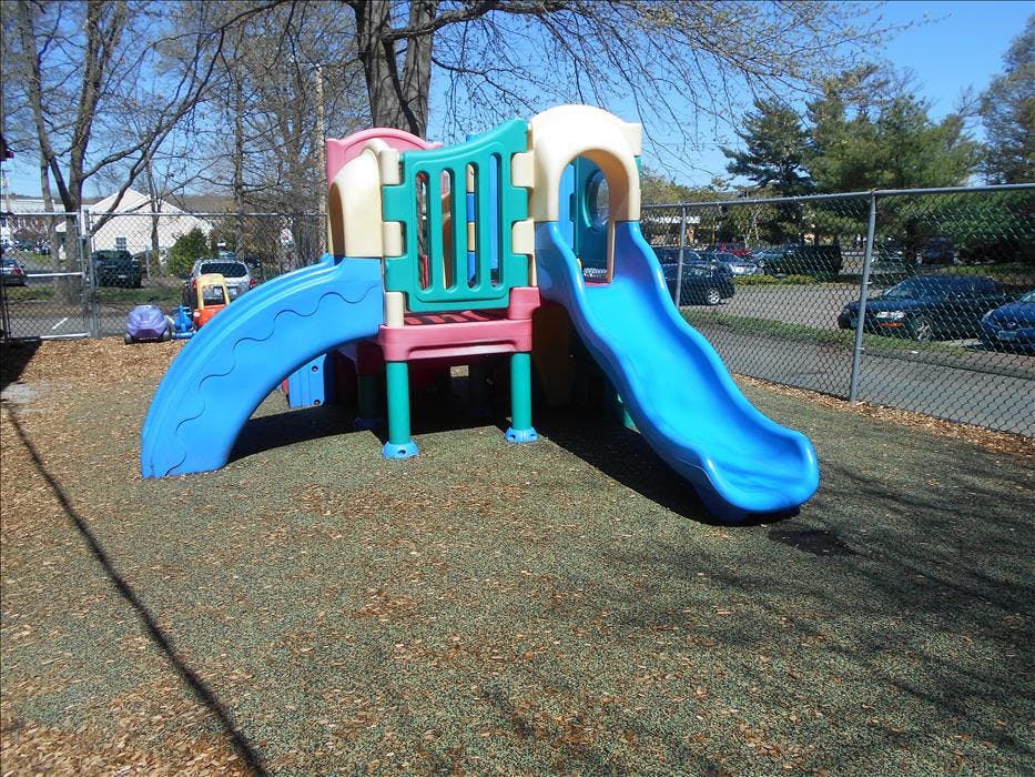 A colorful plastic playground structure with two slides