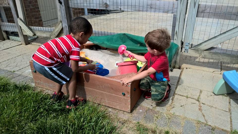 Two children playing in a sandbox