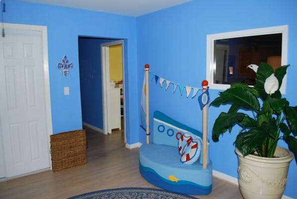 Room with blue walls, a boat-shaped bed, and a potted plant